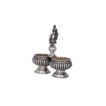 Pair of silver salt shakers with decorative top on a light gray background