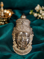 Silver mukham idol for pooja, detailed deity face with tall crown and ornaments.