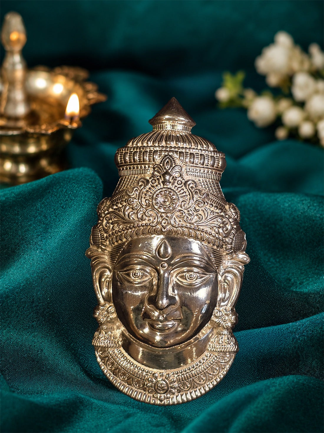 Silver mukham idol for pooja, detailed deity face with tall crown and ornaments.