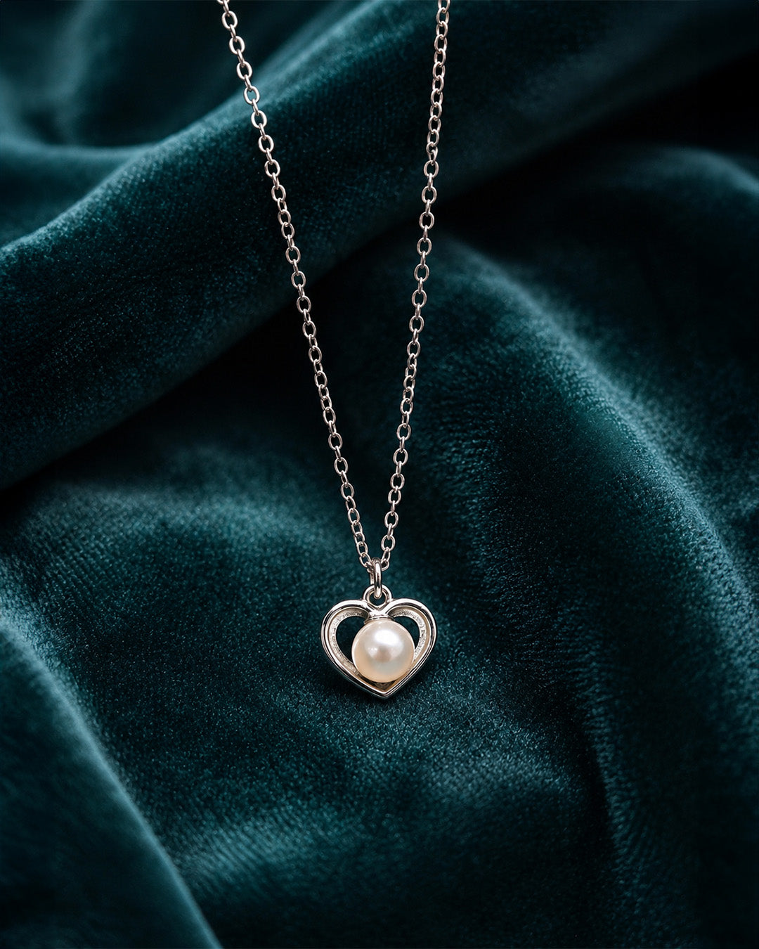 Silver heart-shaped pendant with a pearl