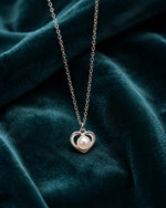Silver heart-shaped pendant with a pearl