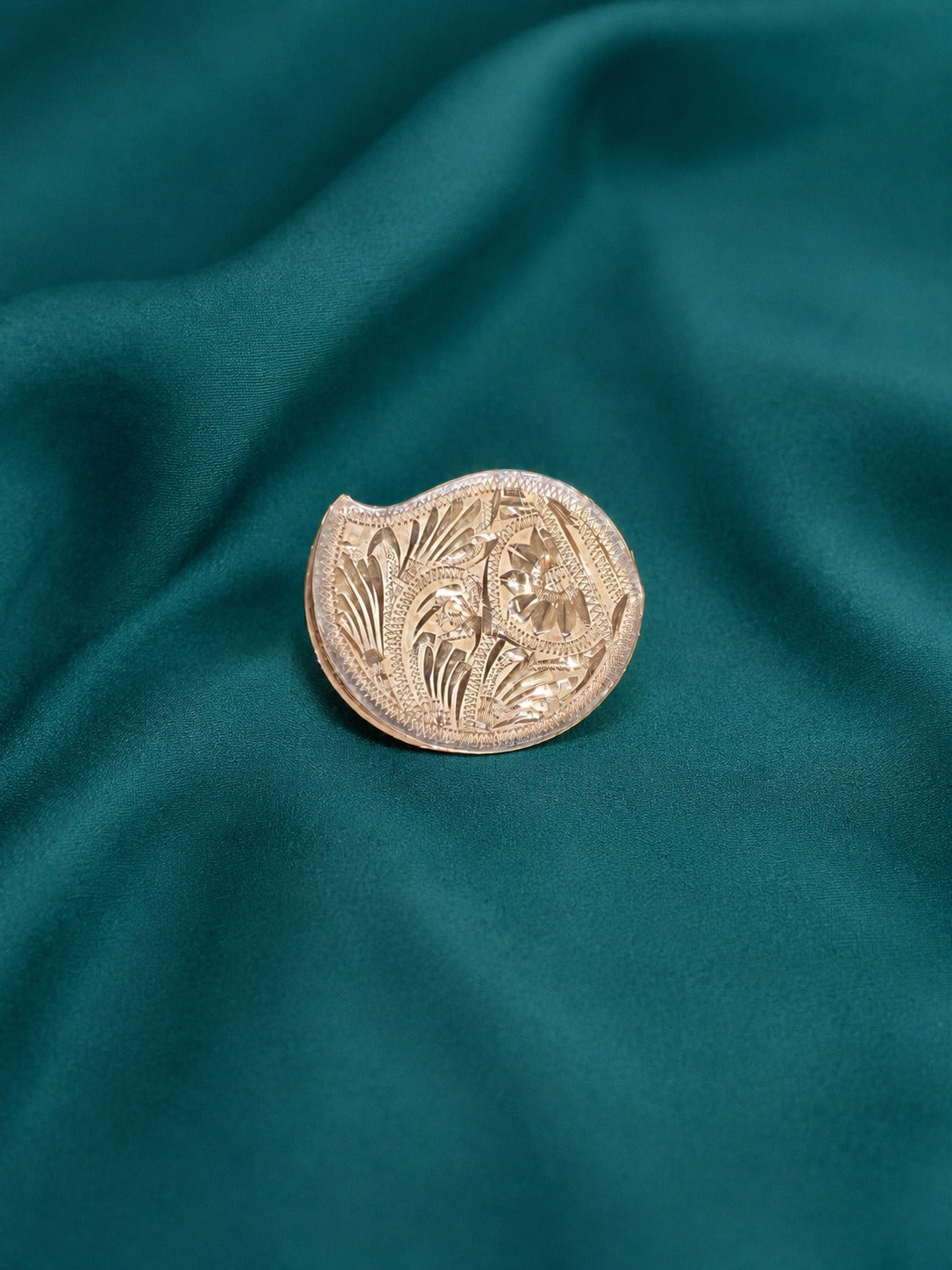 Round embossed gold-tone pooja kumkum box with floral border motif and textured rim