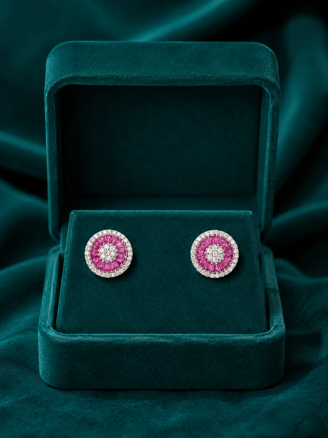 Shop pair of round silver earrings for womens with pink gemstones and diamond-like elements in green box.