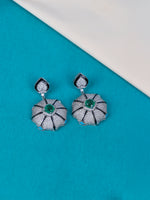 Shop a pair of silver dangle earrings with textured pave floral drops and central green stone accents.