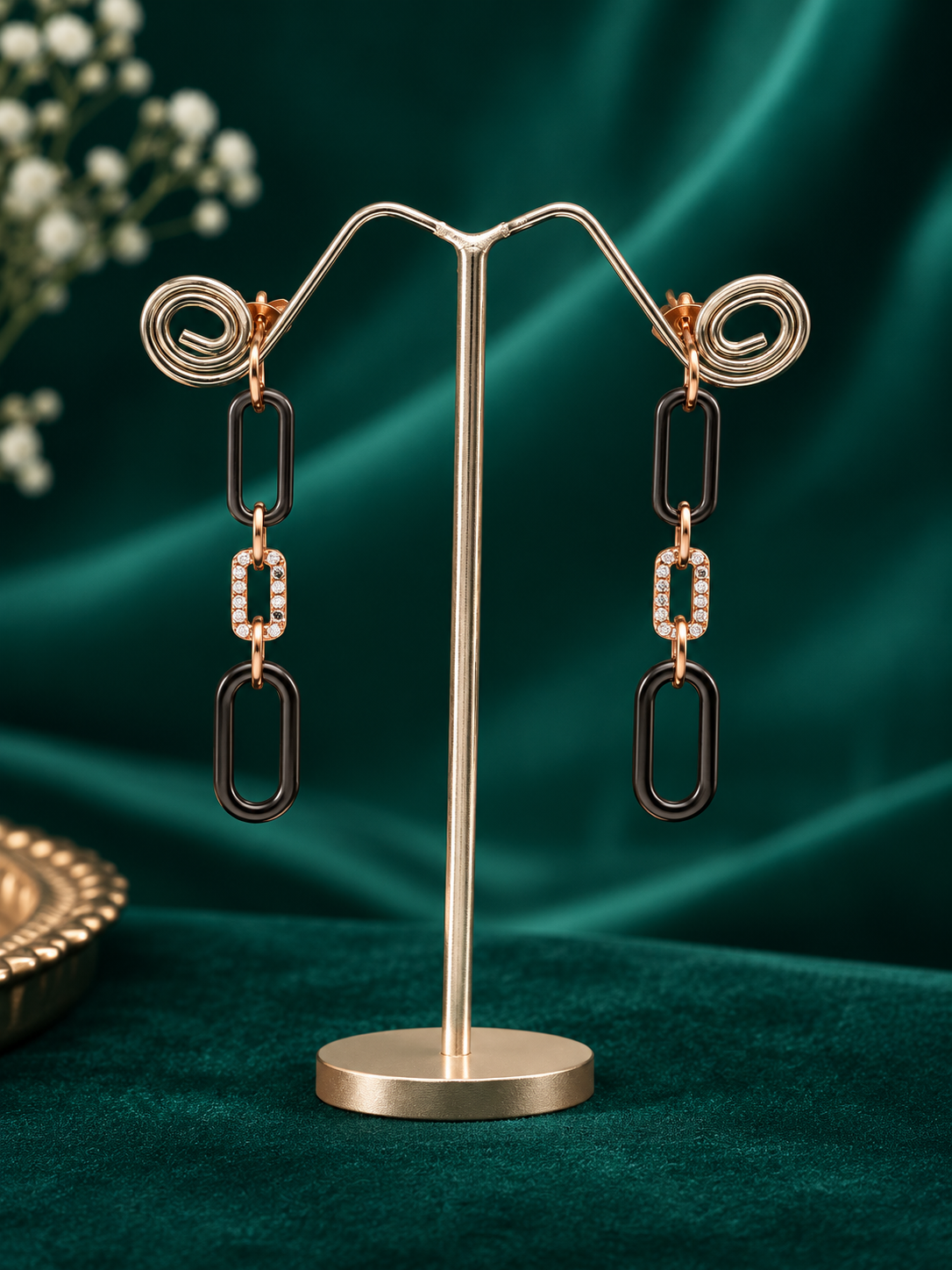 Designer silver dangle earrings with elongated black links, rose-gold accents and clear crystals.