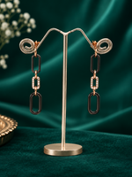 Designer silver dangle earrings with elongated black links, rose-gold accents and clear crystals.