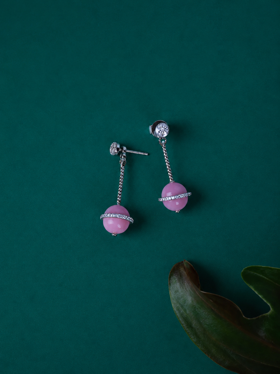 A pair of silver drop earrings with pink stone beads and clear rhinestone accents.