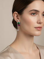 A woman wearing a dangling rectangular drop silver earring.