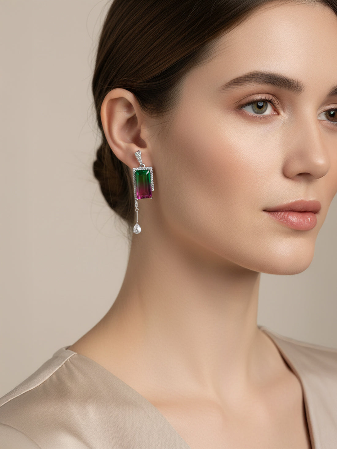 A woman wearing a dangling rectangular drop silver earring.