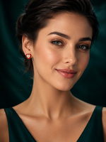 Woman wearing red heart-shaped silver earrings with sparkling white centre stones.