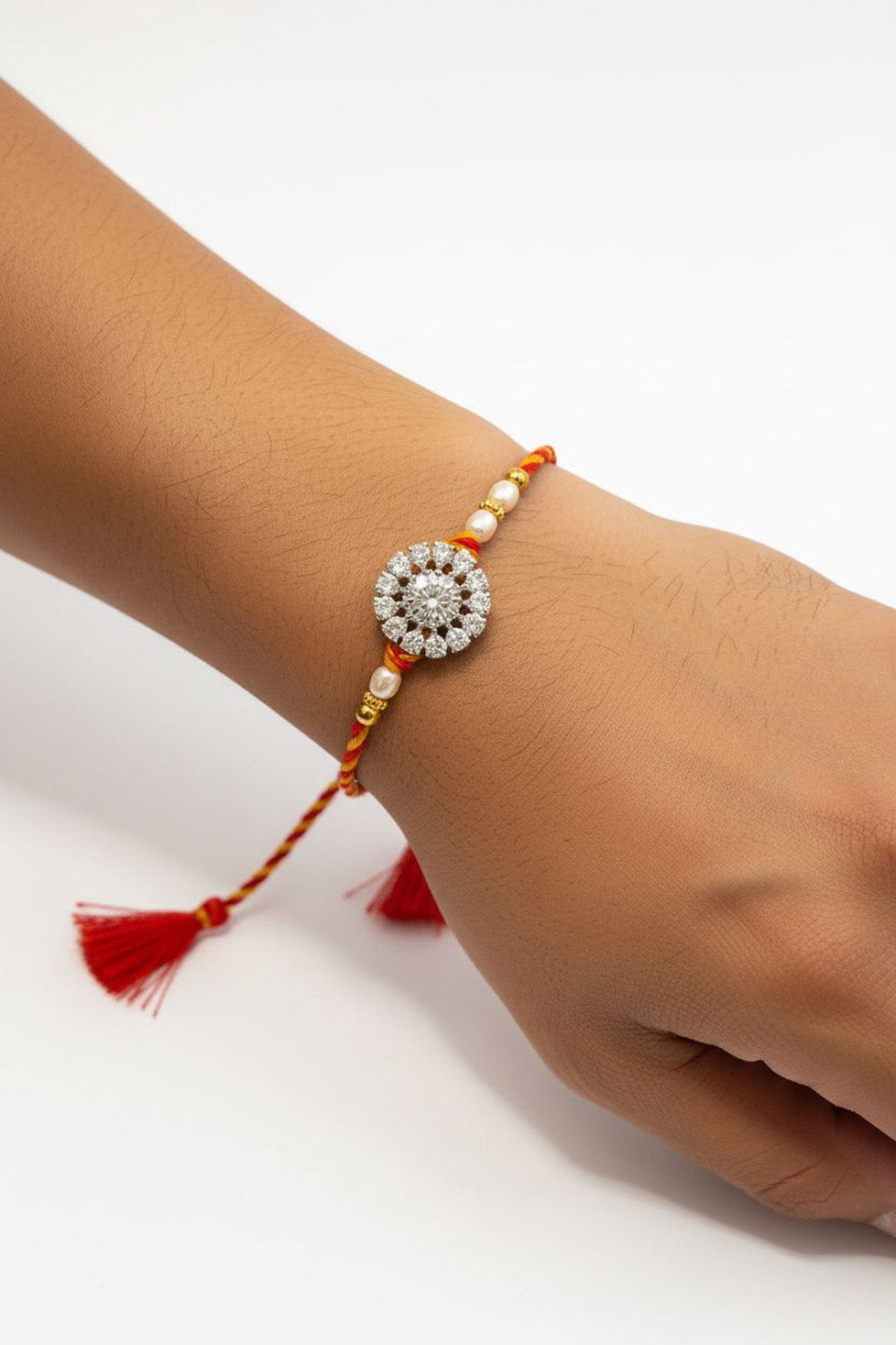 Sterling silver floral rakhi with pearl beads, red braided thread and tassel