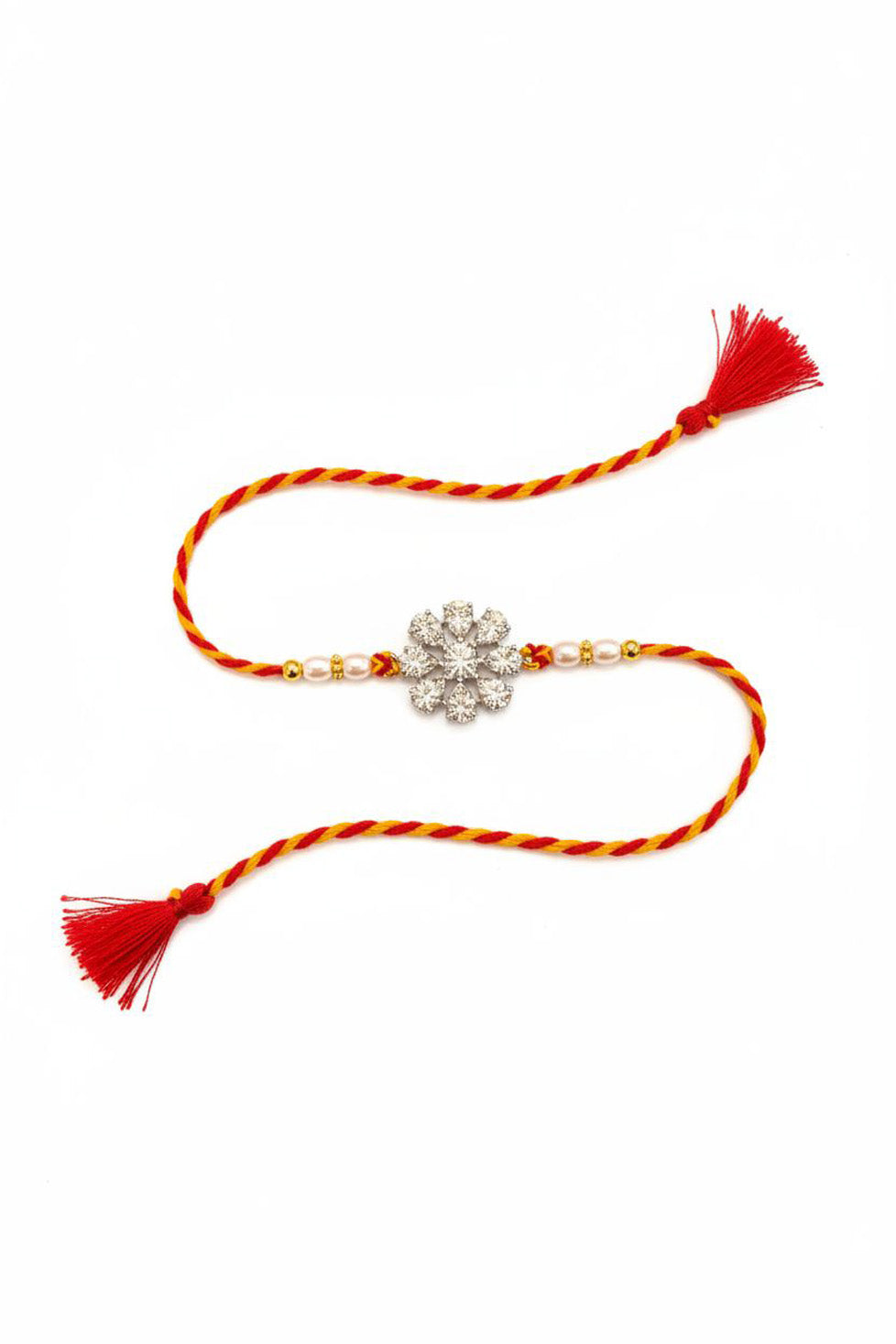 Silver flower rakhi with red-yellow braided thread, pearl beads, and red tassels