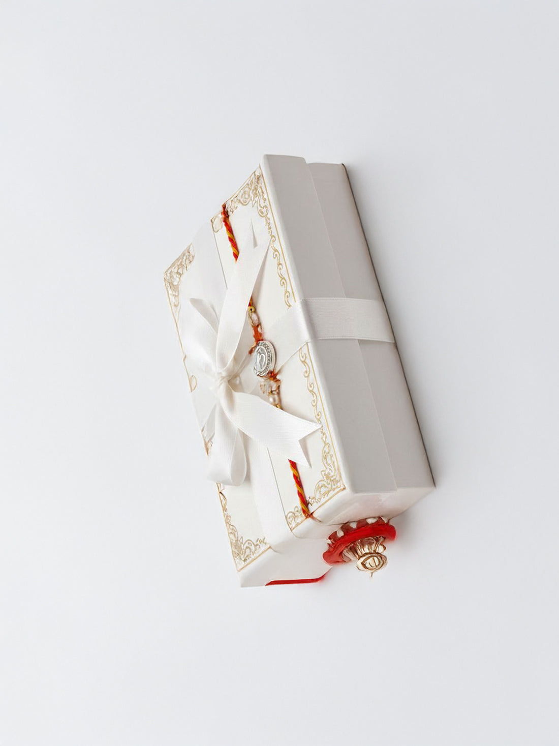 Sterling silver round rakhi with pearl beads and red tassels in a gift box