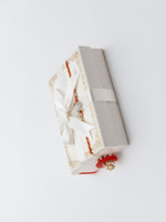 Sterling silver round rakhi with pearl beads and red tassels in a gift box