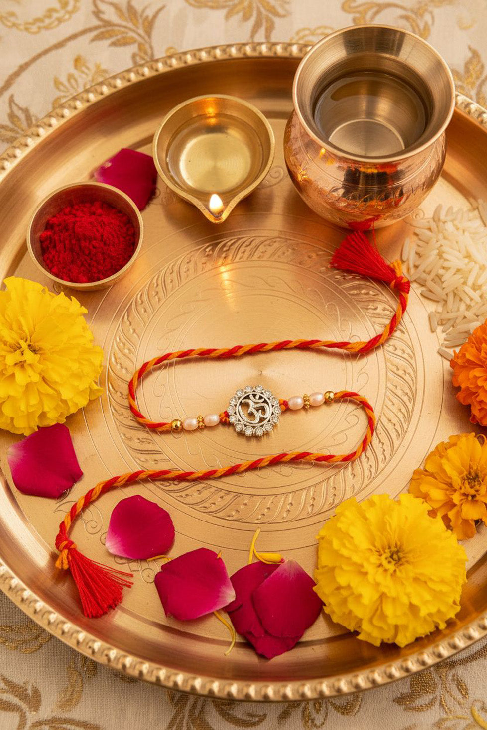 Red thread rakhi with silver circular pendant, small pearl beads, double tassels
