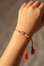 Sterling silver round floral cutwork rakhi bracelet with pearl beads and red tassels