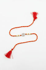 Sterling silver floral disc rakhi with red thread, pearl beads, and tassels