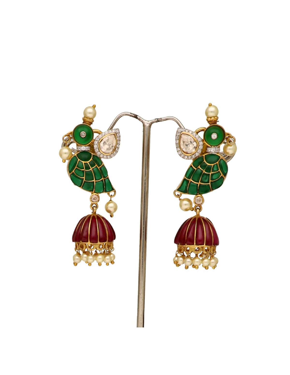 Close-up of traditional dangling earrings with green enamel leaves and red tassels
