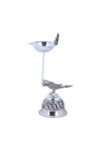 Silver-tone pooja diya lamp with pedestal, engraved base, and bird & deity figurines