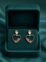 Designer silver earrings with open-heart drops and decorative stone accents along the lower edge.