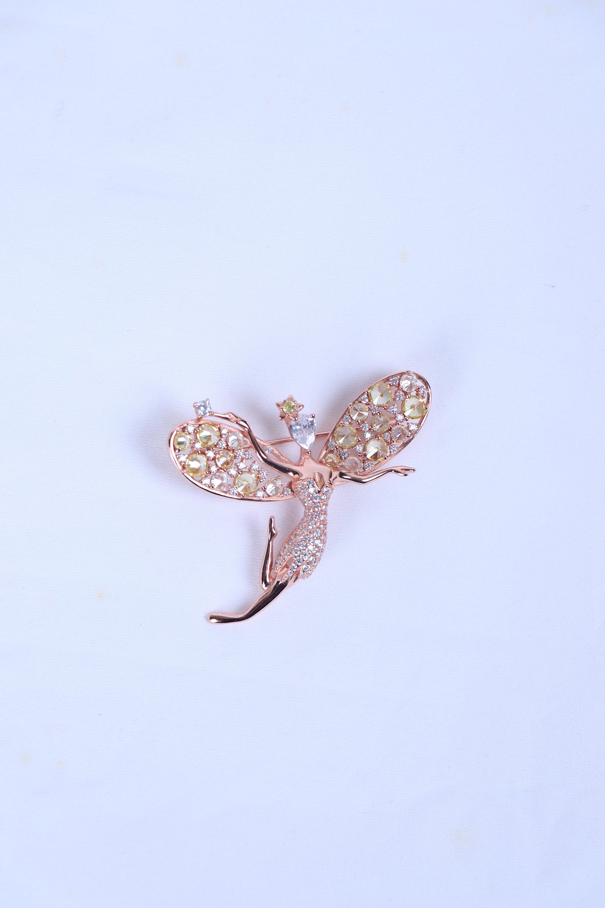 Designer silver brooch featuring a crystal-studded bird motif worn on a sherwani pocket.