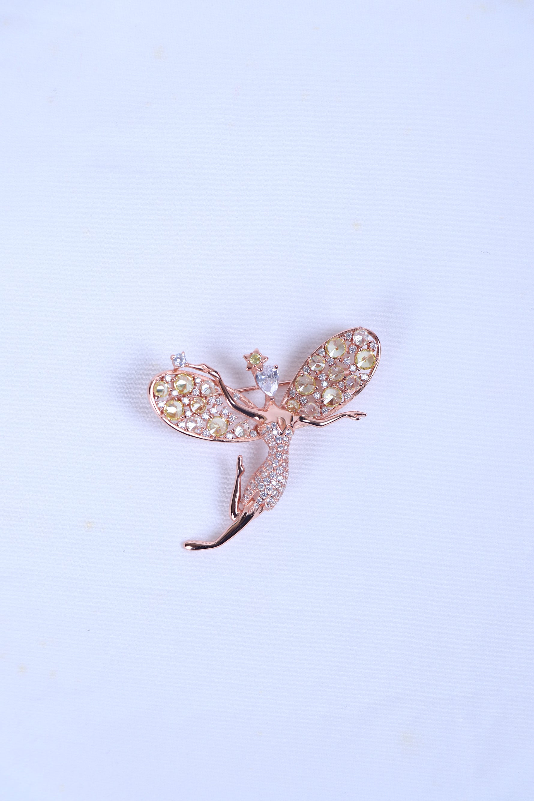 Designer silver brooch featuring a crystal-studded bird motif worn on a sherwani pocket.
