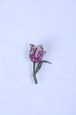 Designer silver brooch featuring a pink rose motif pinned to a sherwani pocket.