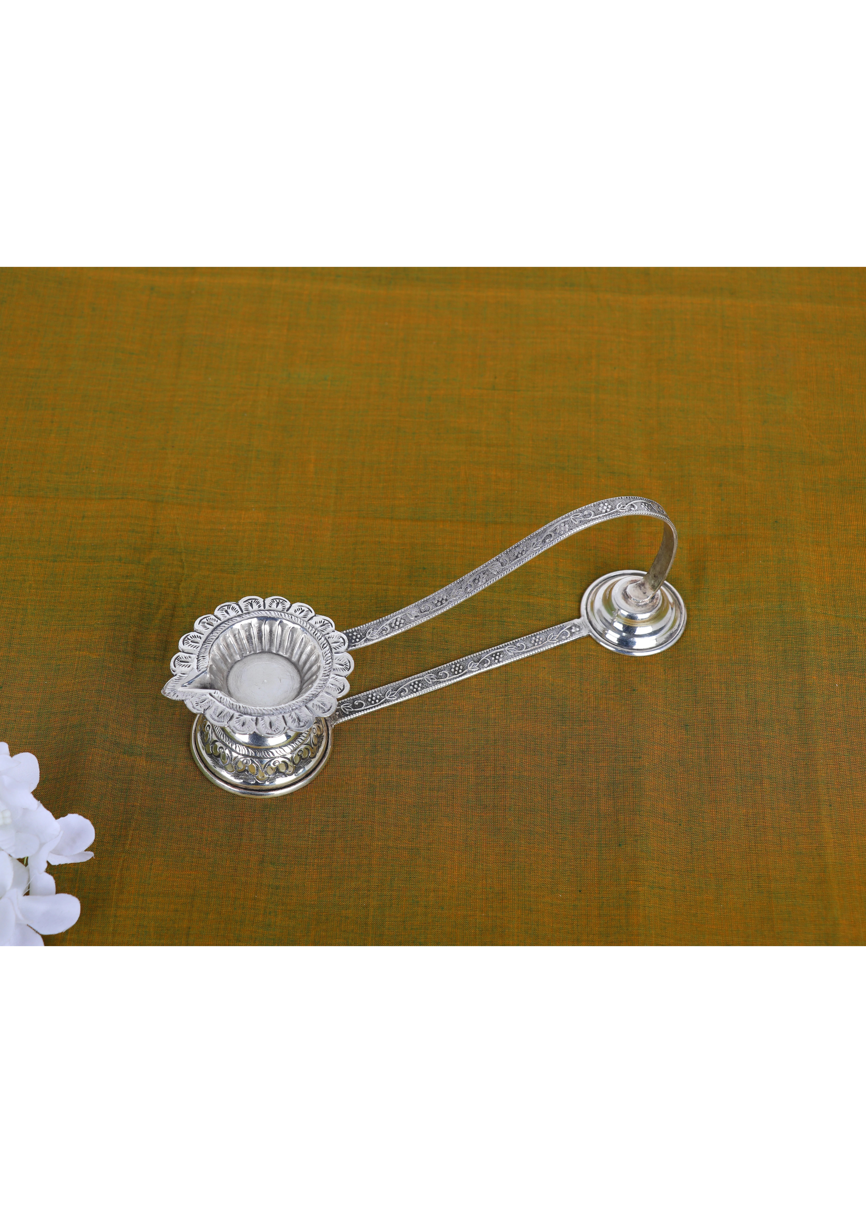 Silver lotus-petal aarti diya with long handle and wick cup, ornate base