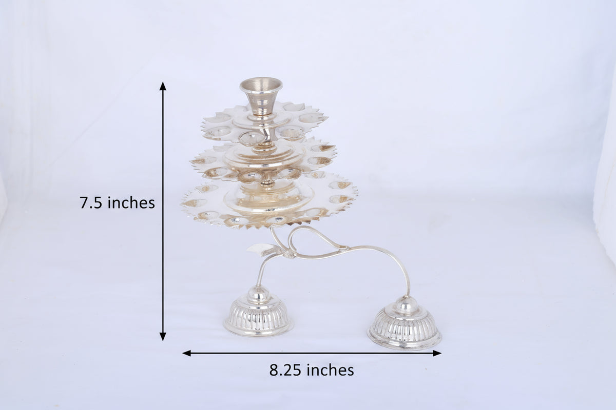 Multi-tier silver aarti lamp with stacked plates and two diya holders, full view