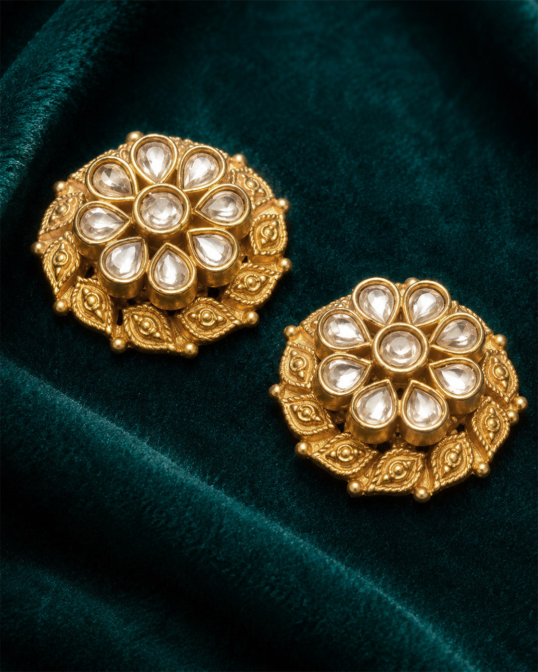 Pair of silver earrings with intricate designs with gold print.