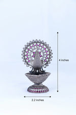 Silver-tone peacock oil diya, 2.2 in wide and 4 in tall, purple gemstone fan