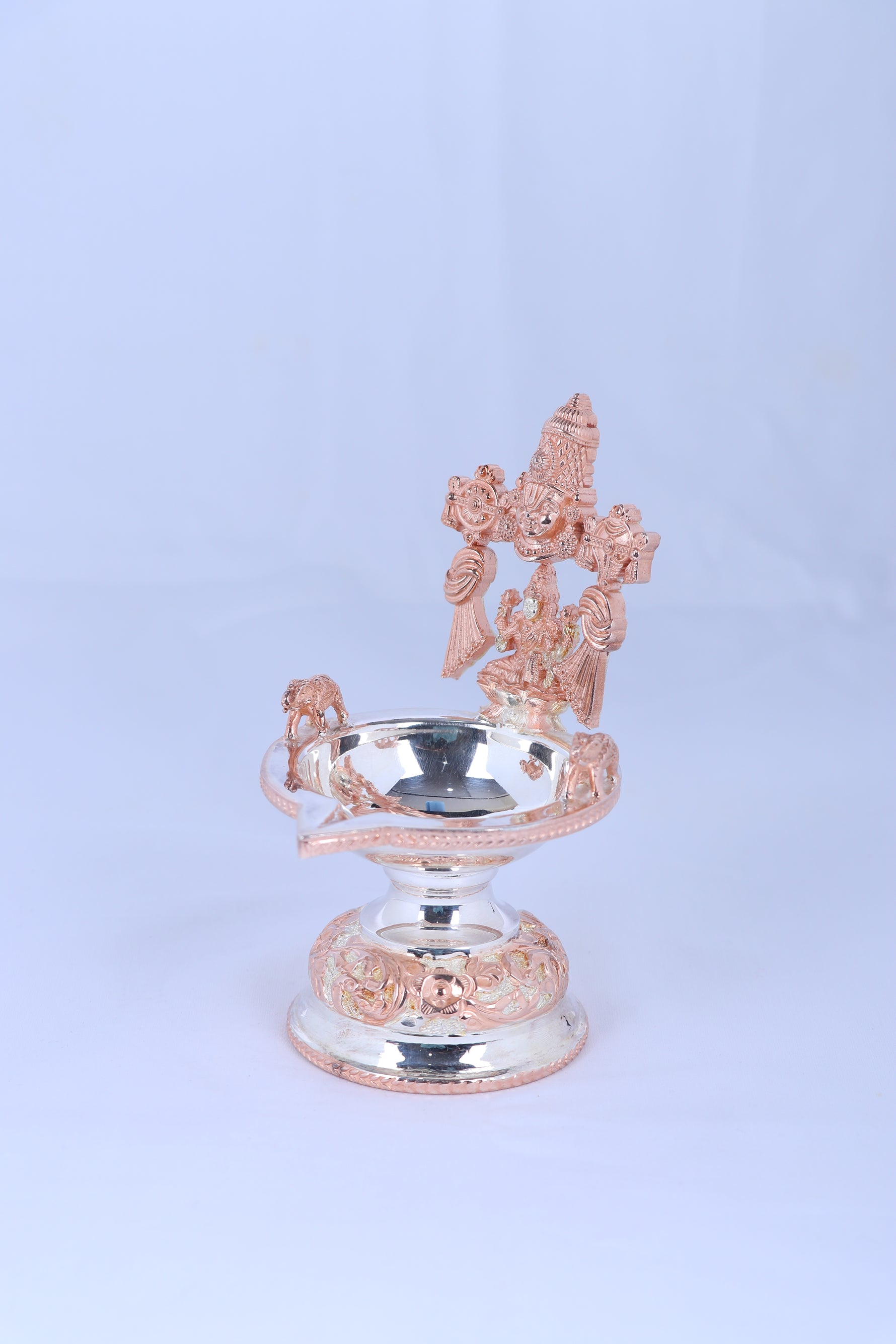 Side view of silver-toned Lakshmi diya with prabhavali, round oil bowl on pedestal