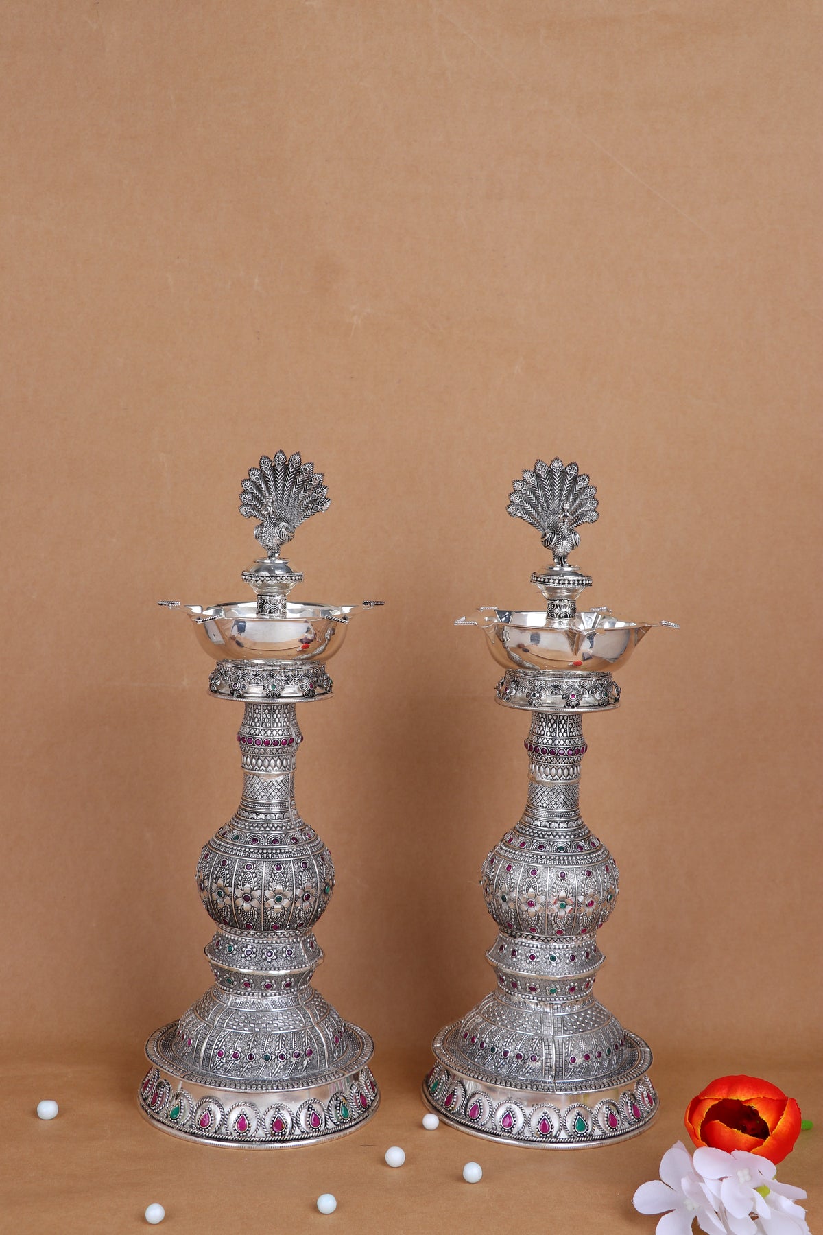 Pair of silver peacock diya stands with multi-tier stems and colorful enamel accents