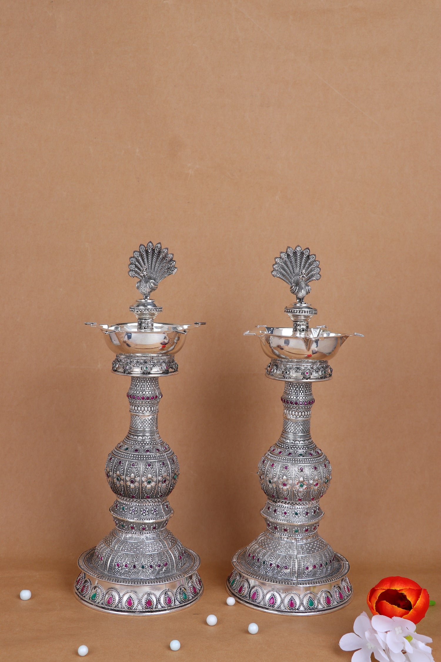 Pair of silver peacock diya stands with multi-tier stems and colorful enamel accents
