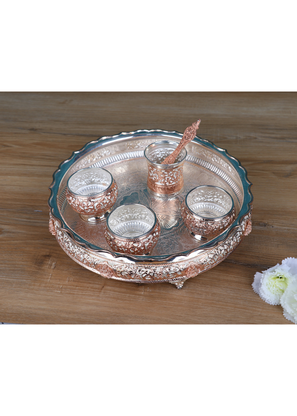 Angled view: Silver-tone pooja thali with five small cups and a center raised holder