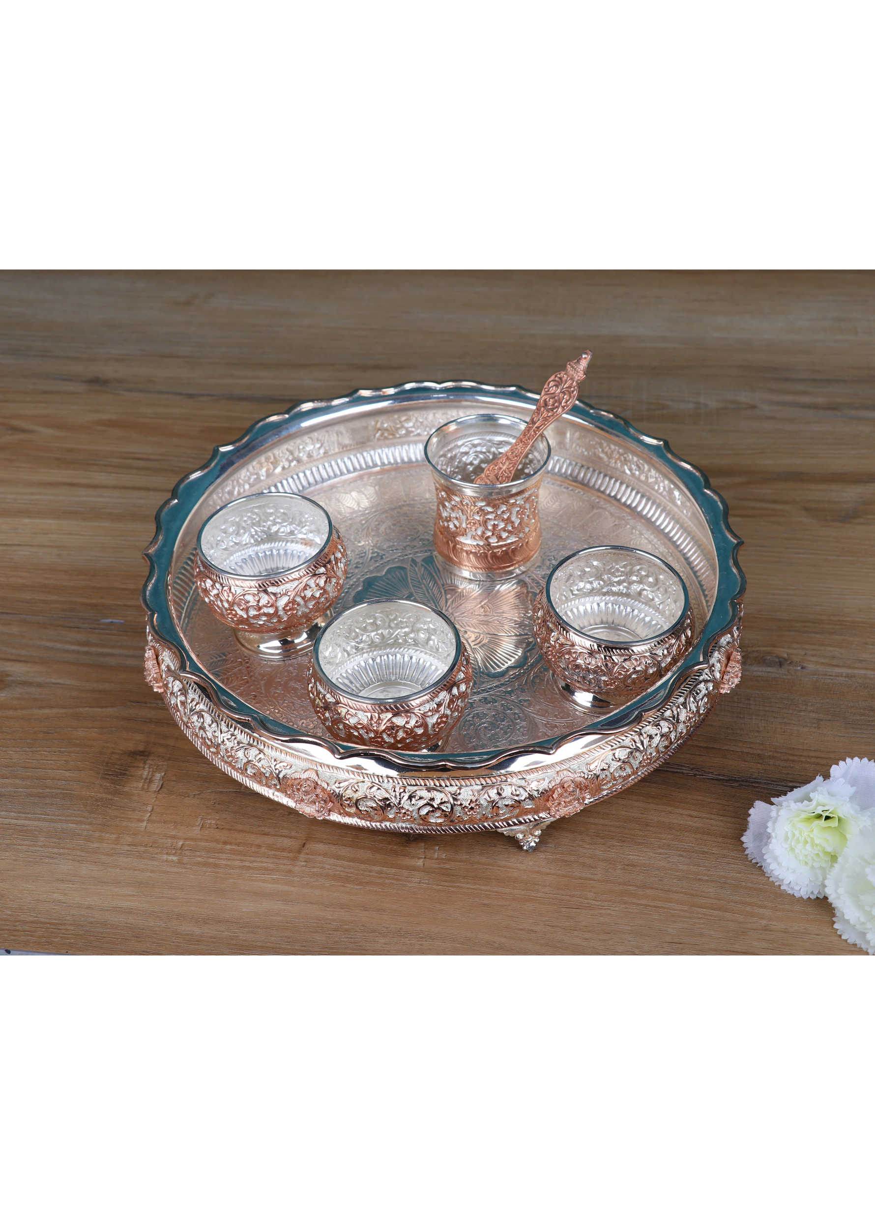 Angled view: Silver-tone pooja thali with five small cups and a center raised holder