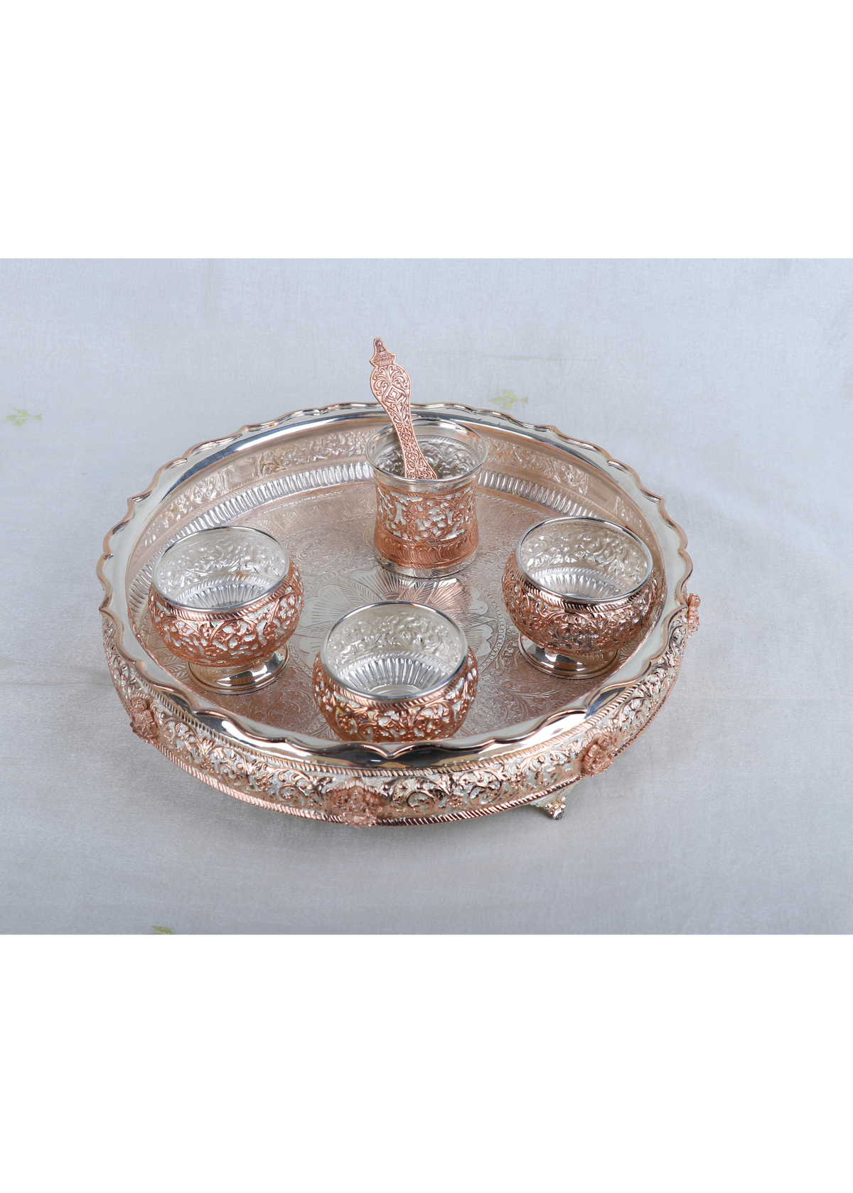 Top view: Silver-tone pooja thali with five small cups and a center raised holder