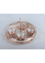Top view: Silver-tone pooja thali with five small cups and a center raised holder