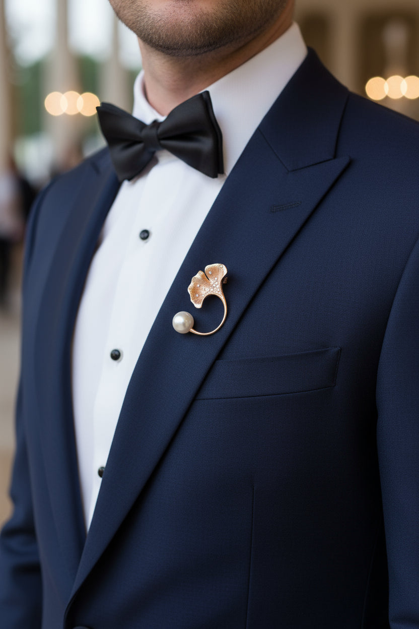 Pure silver leaf brooch with pearl accent worn on a navy blue tuxedo lapel.