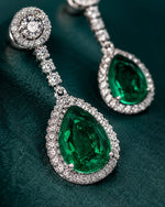 Pure silver long earrings for women featuring large green stones and rows of clear crystals.