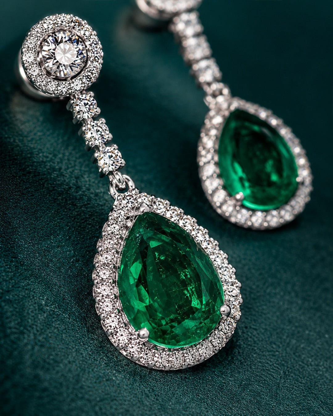Pure silver long earrings for women featuring large green stones and rows of clear crystals.