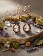Pure silver oval stud earrings for women with a faceted white centre stone and sparkling crystal border.