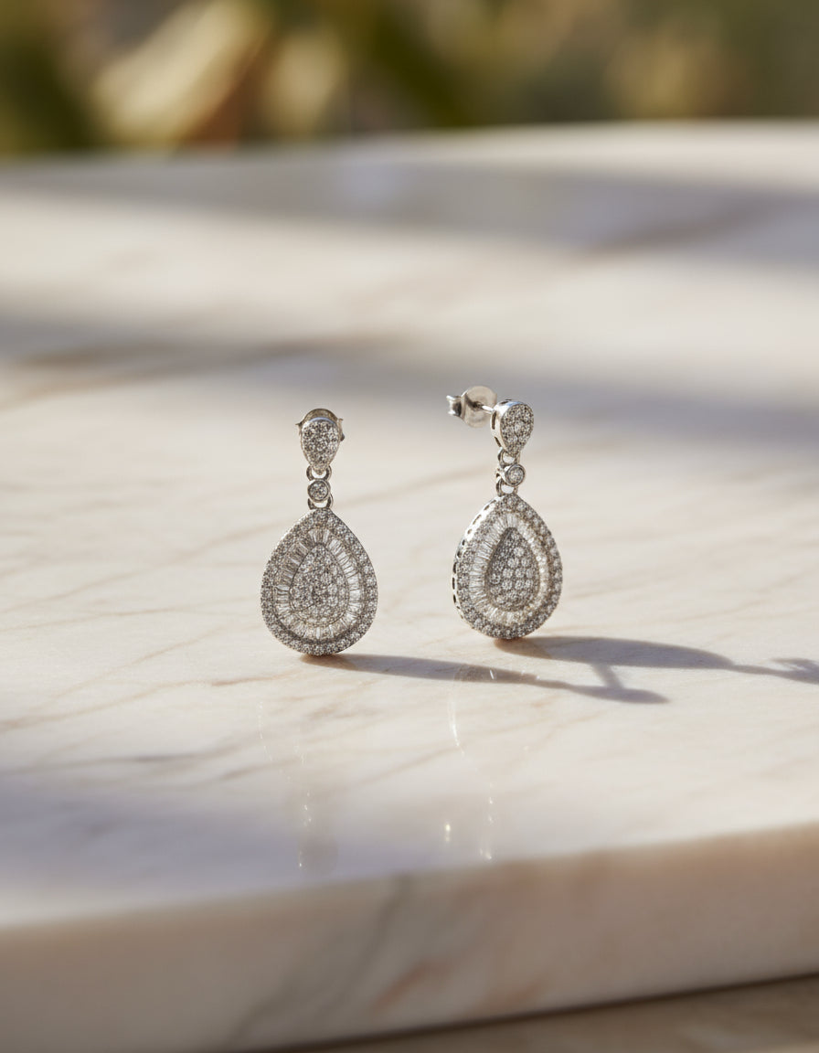 Shop crystal-studded silver dangle earrings for women with an intricate layered halo design.