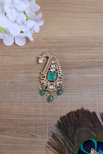 Shop silver brooch online with elegant paisley motif and green stone accents.