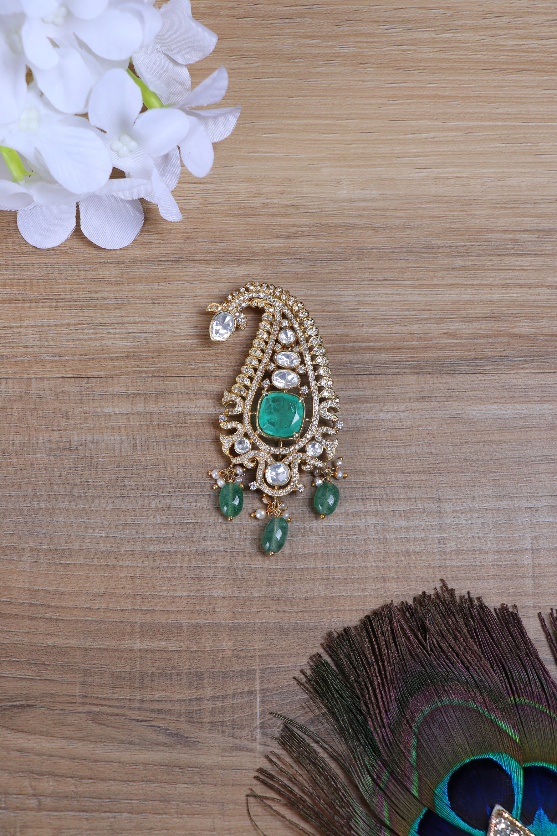 Shop silver brooch online with elegant paisley motif and green stone accents.