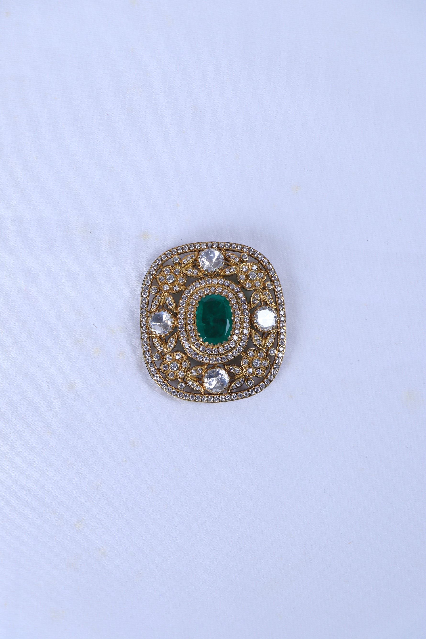 Silver brooch for men with green stone and crystal detailing on a formal sherwani.