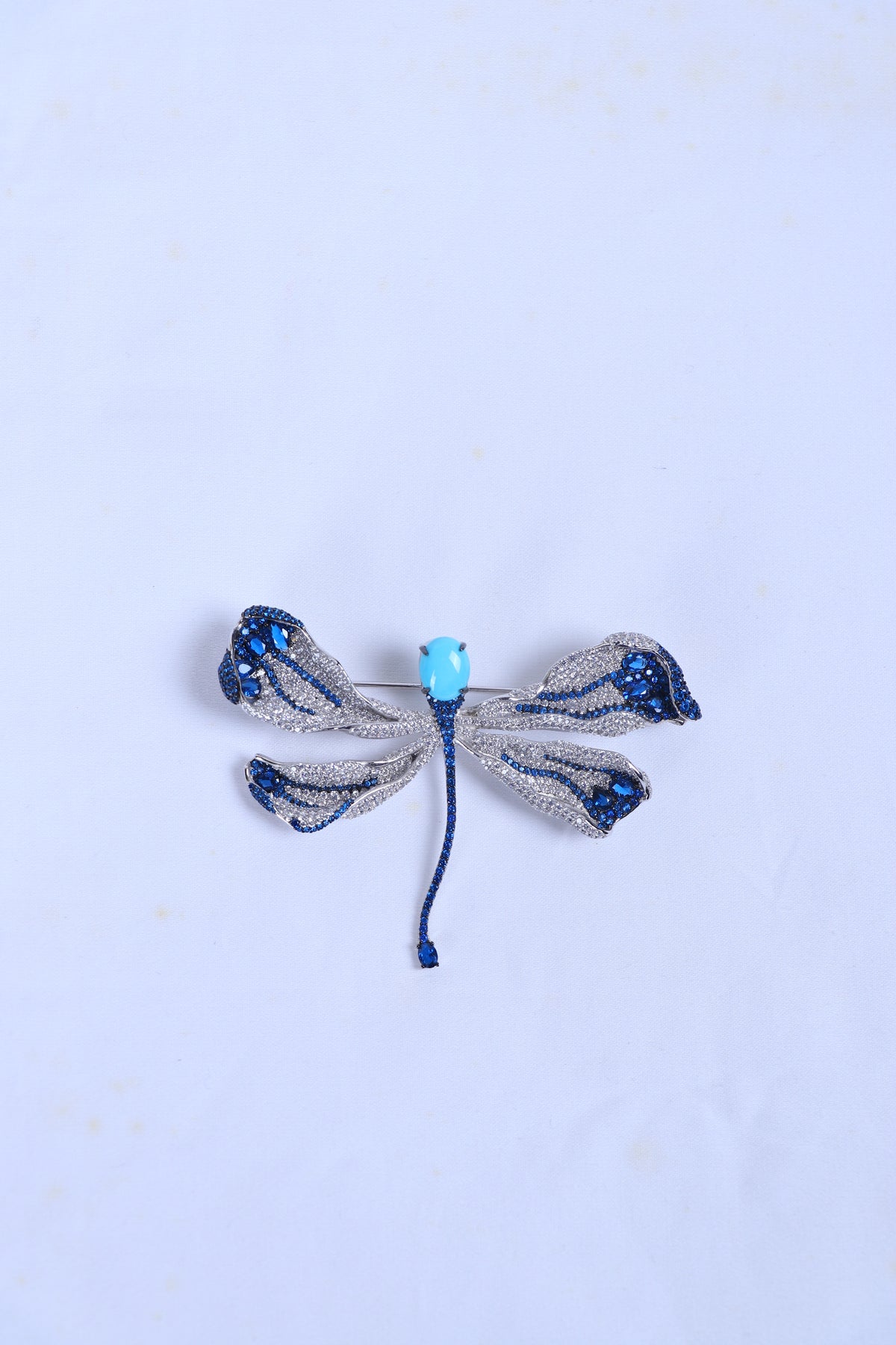 Blue and silver bow rhinestone brooch with light-blue center bead and blue ties