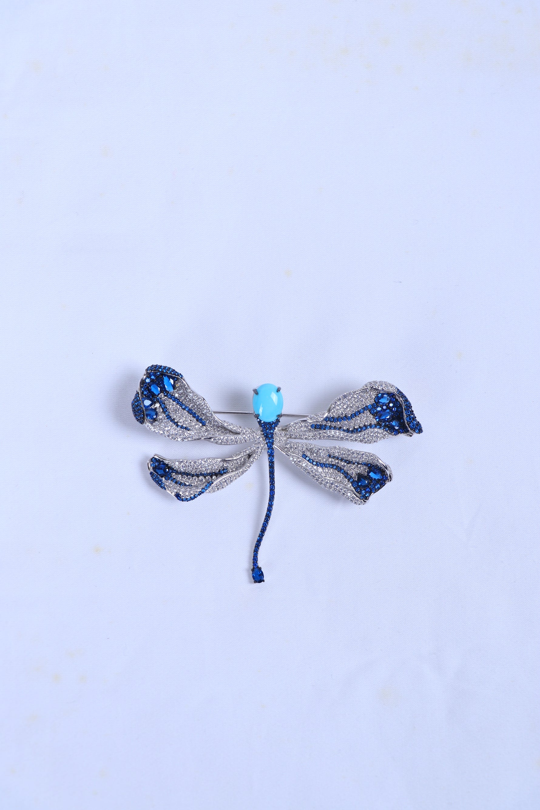 Blue and silver bow rhinestone brooch with light-blue center bead and blue ties