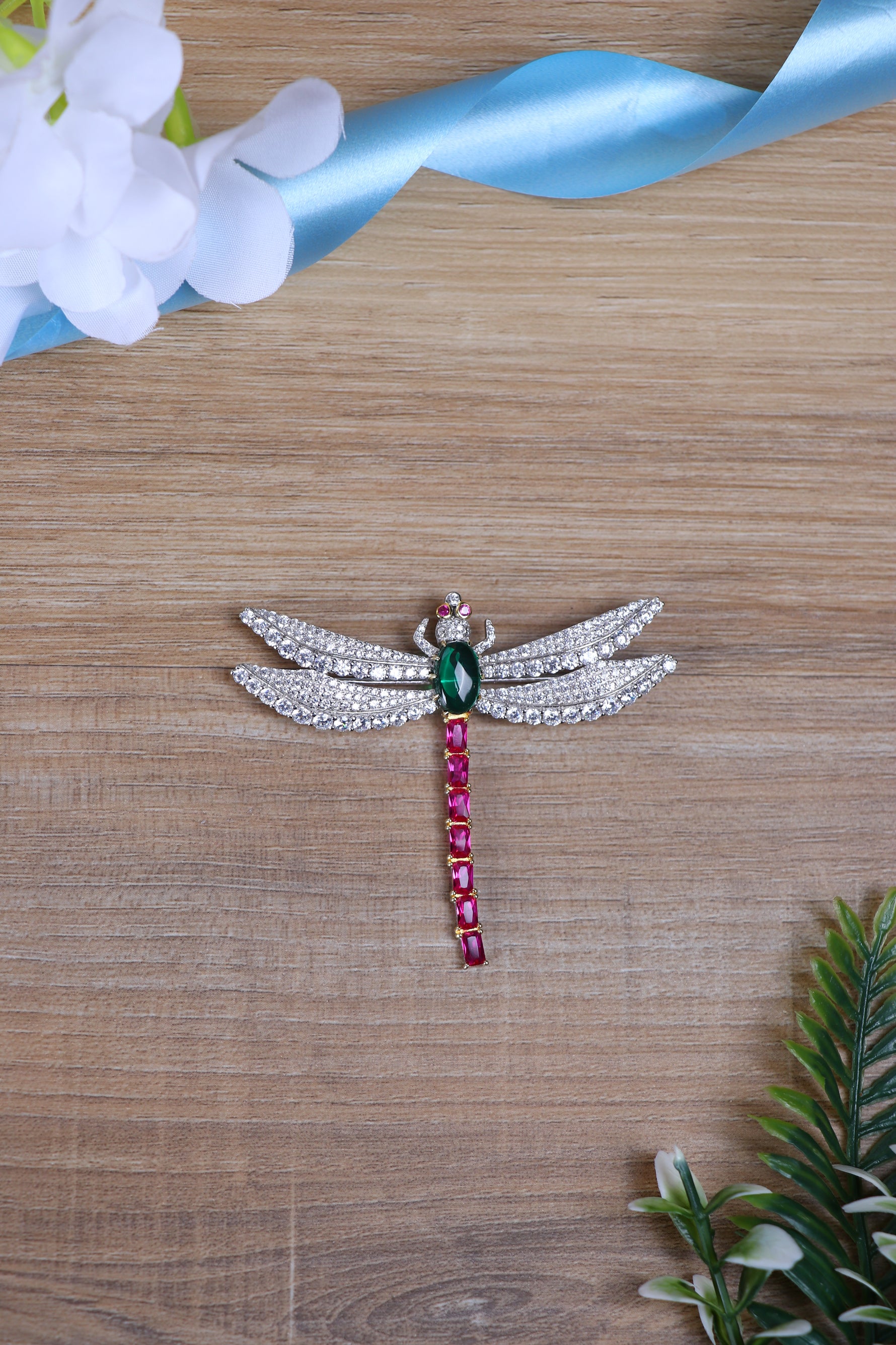 Silver brooch for men featuring wing design with sparkling crystals and coloured stones.