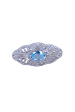 Silver designer brooch with oval blue gemstone and ornate filigree settings
